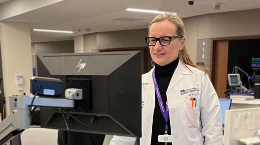 Agniezka Ardelt standing at a computer in her hospital